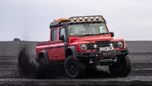 red ineos grenadier quartermaster with portal axles kicking up the dust in iceland