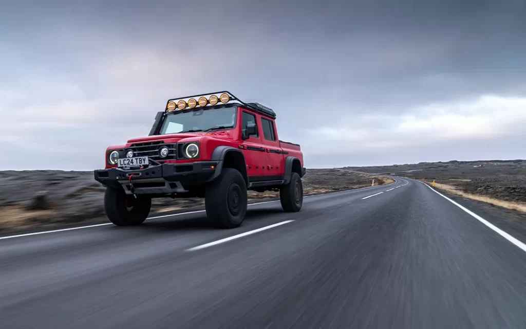 Roter Ineos Grenadier mit Portalachsen auf der Straße.