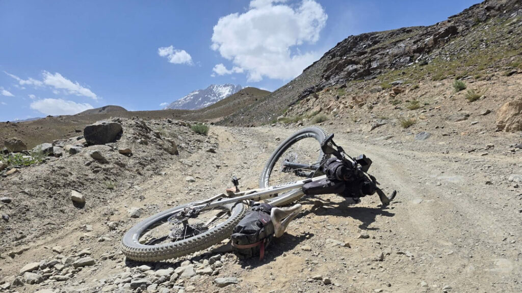 bicycle lying on a track in the middle of central asia on the Pamir highway