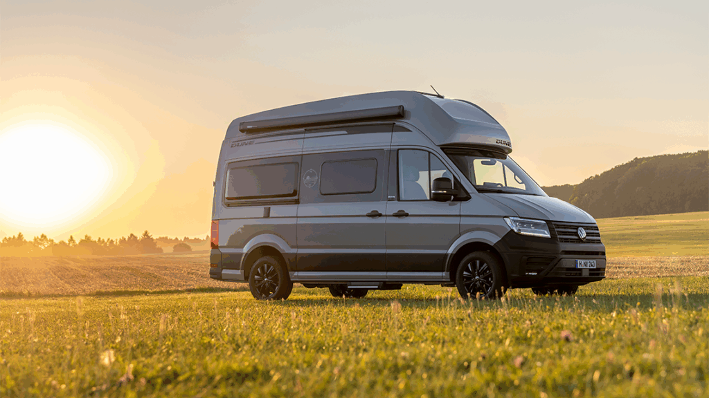 Grand California Dune 600 auf einer Wiese mit untergehender Sonne im Hintergrund
