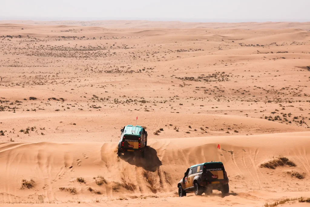 zwei defender dakar rennwagen auf dem weg in die wüste
