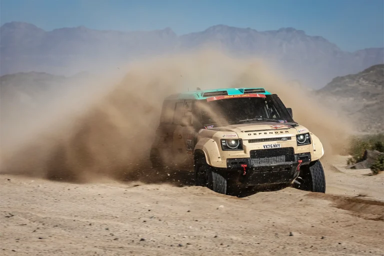 defender throwing up sand in the desert