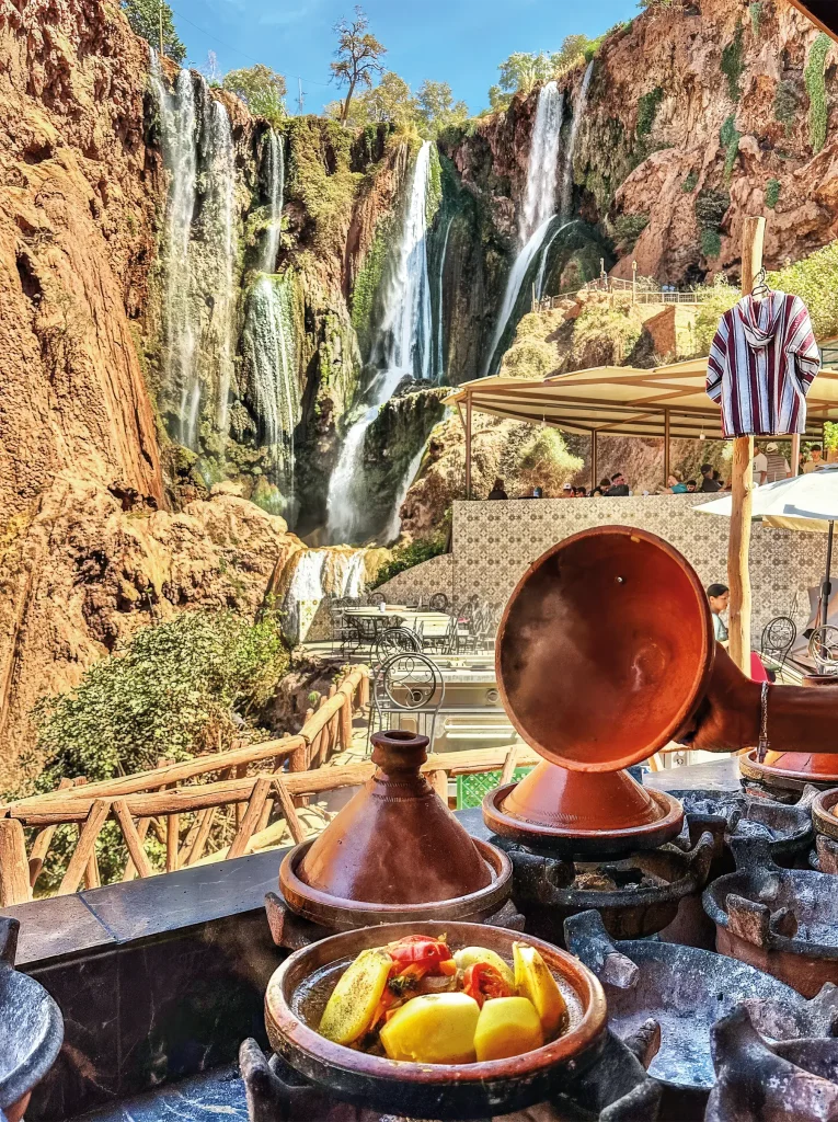 Moroccan tajine cooking on a terrace overlooking Ouzoud Falls.