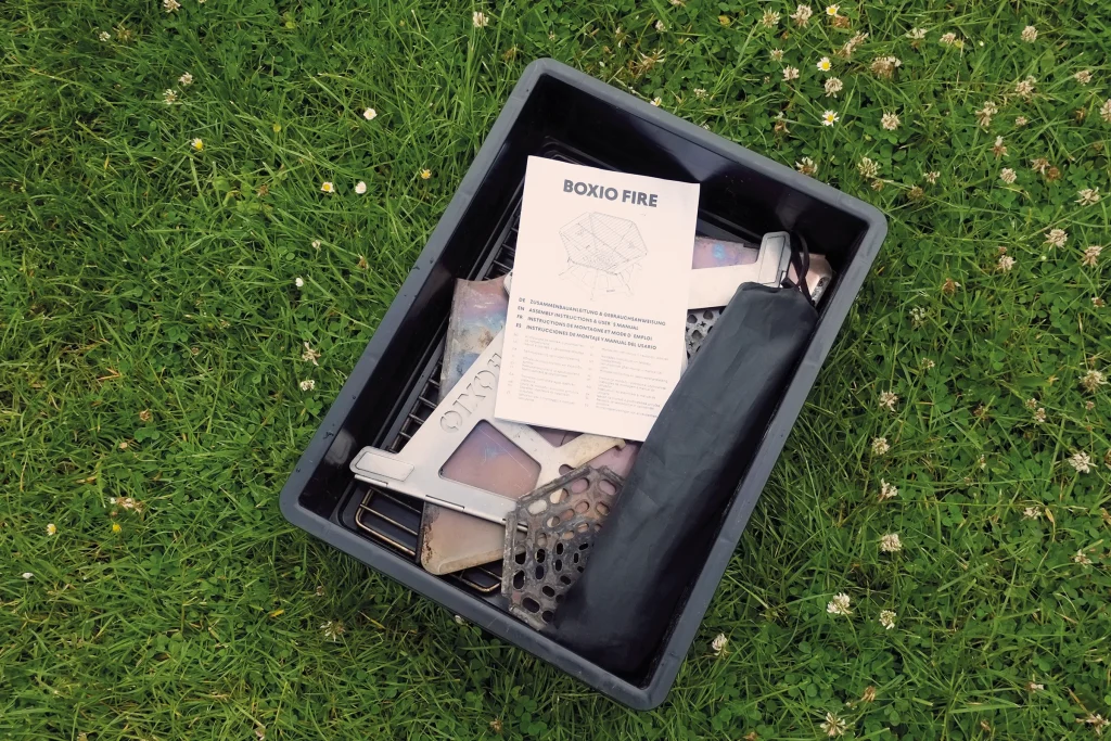 BOXIO FIRE components packed neatly inside a Eurobox, including grill parts, fire plate and instruction manual before assembly.