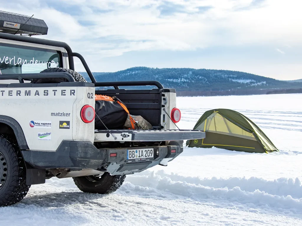 INEOS Grenadier Quartermaster neben dem Big Agnes Crag Lake SL2 auf einem zugefrorenen Fluss in der Arktis.