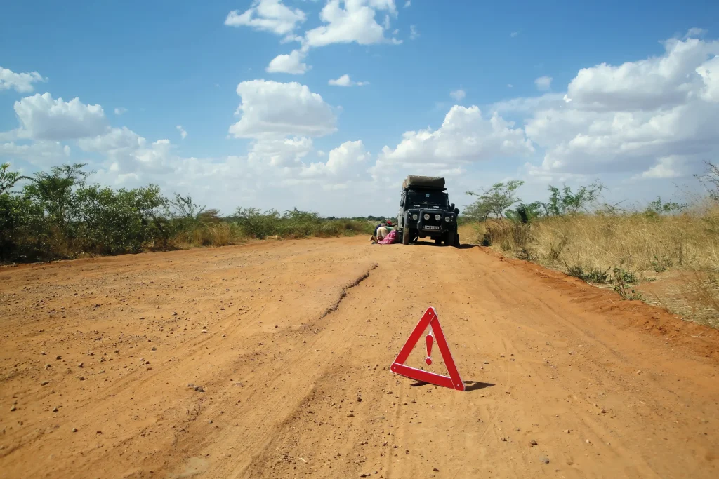 a broken down land rover defender on a sandy track in Tanzania