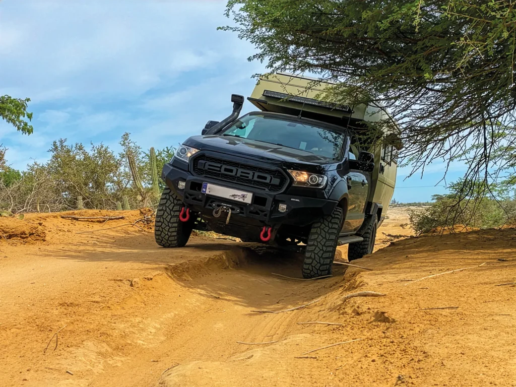 Ford Ranger expedition camper negotiating a deeply rutted sandy track in Colombia.