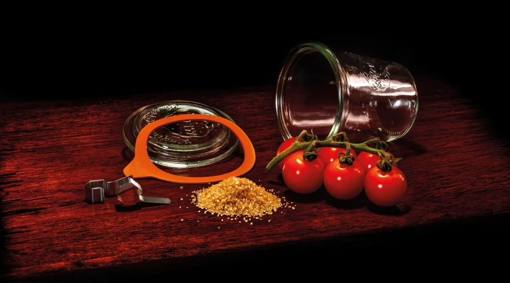 a jar, some fresh tomatoes and brown sugar