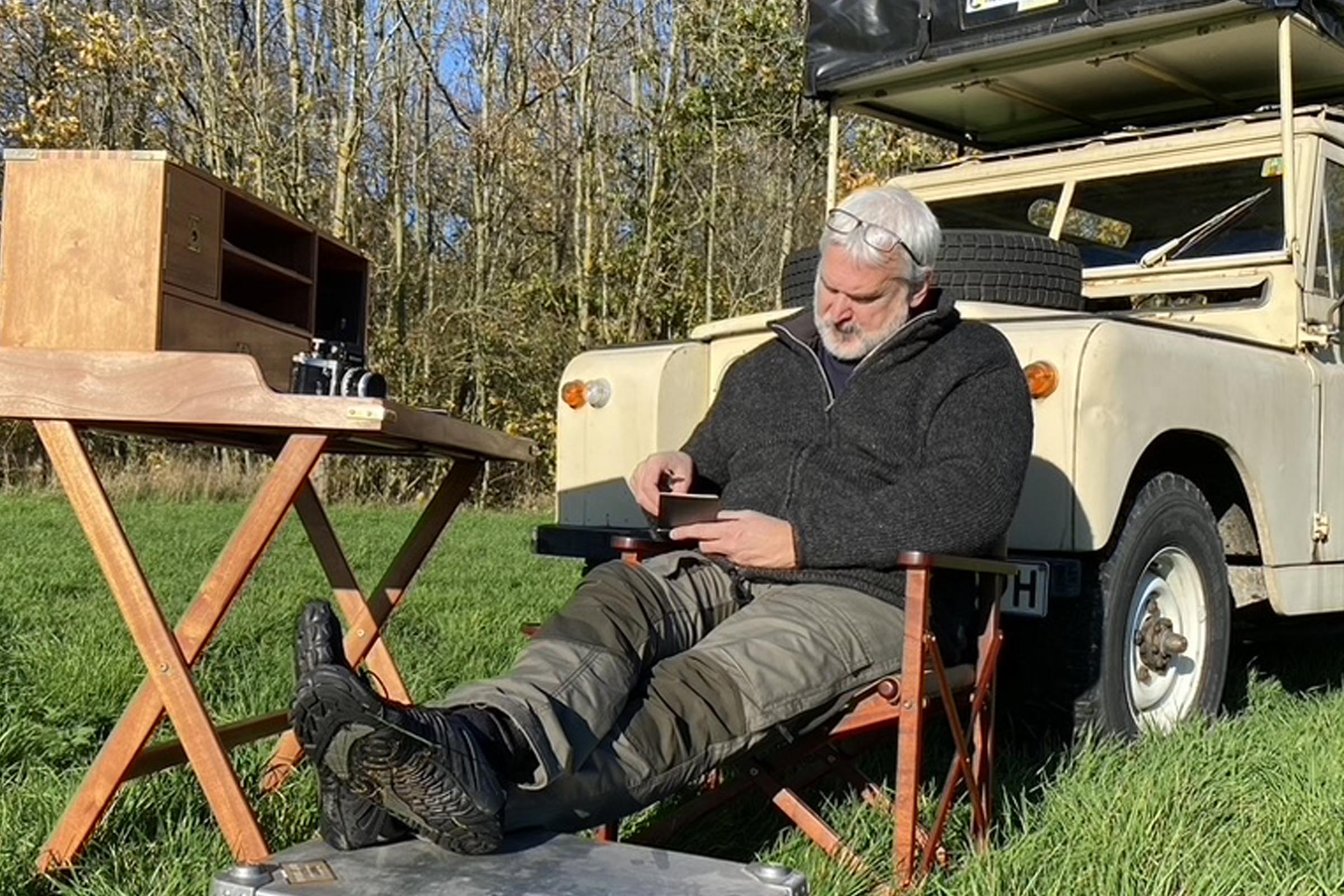 Mike Brailey working beside his Land Rover while recording in the field for the OverlandEurope Podcast.