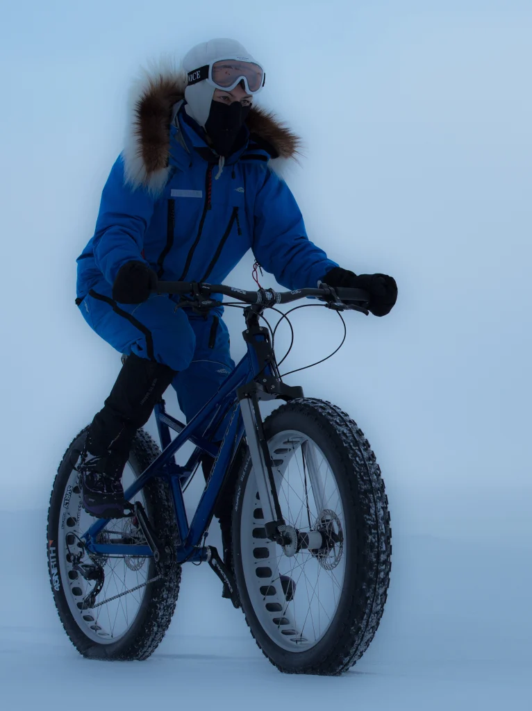 Kate cycling across the ice on her 2-wheel-drive bicycle